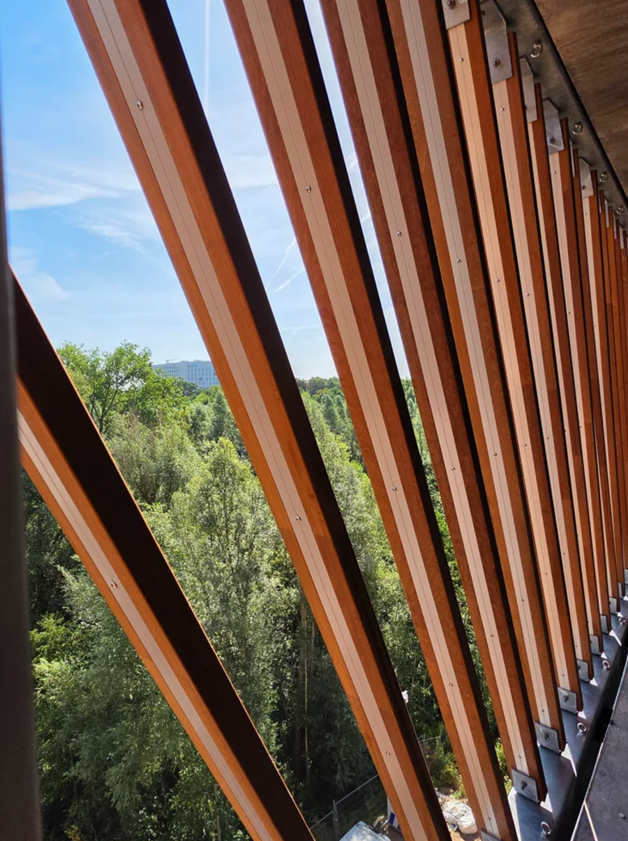 De open opstelling van de lamellen laat licht en lucht door tussen de houten elementen
